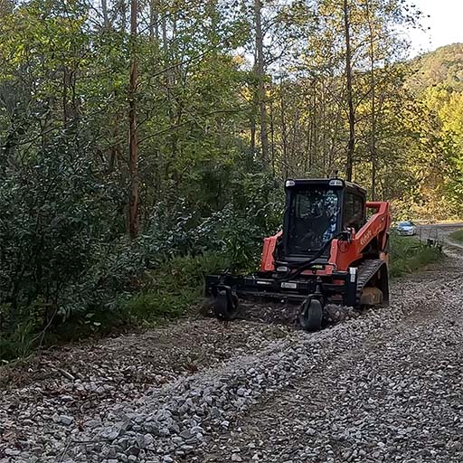 Refreshing a gravel driveway with a power rake.