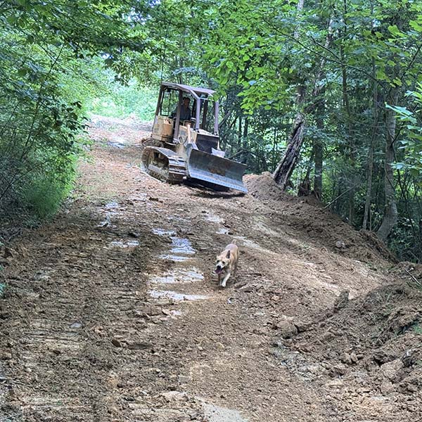 Bulldozer cleaning washed out trails.